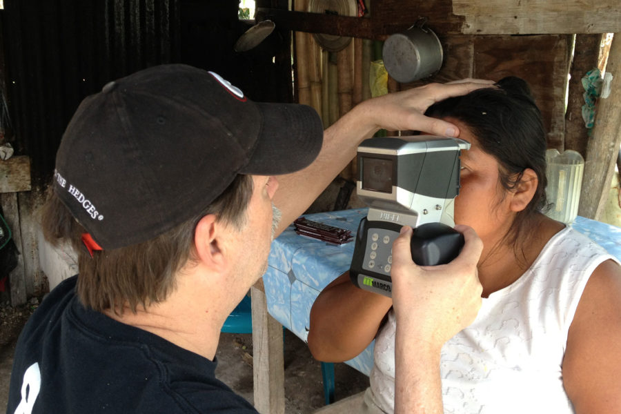 Bryan Kaiser using an autorefractor to measure vision for a woman at a God’s Eyes rural eye clinic.
