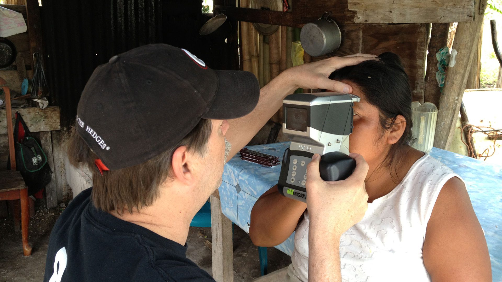 Bryan Kaiser using an autorefractor to measure vision for a woman at a God’s Eyes rural eye clinic.