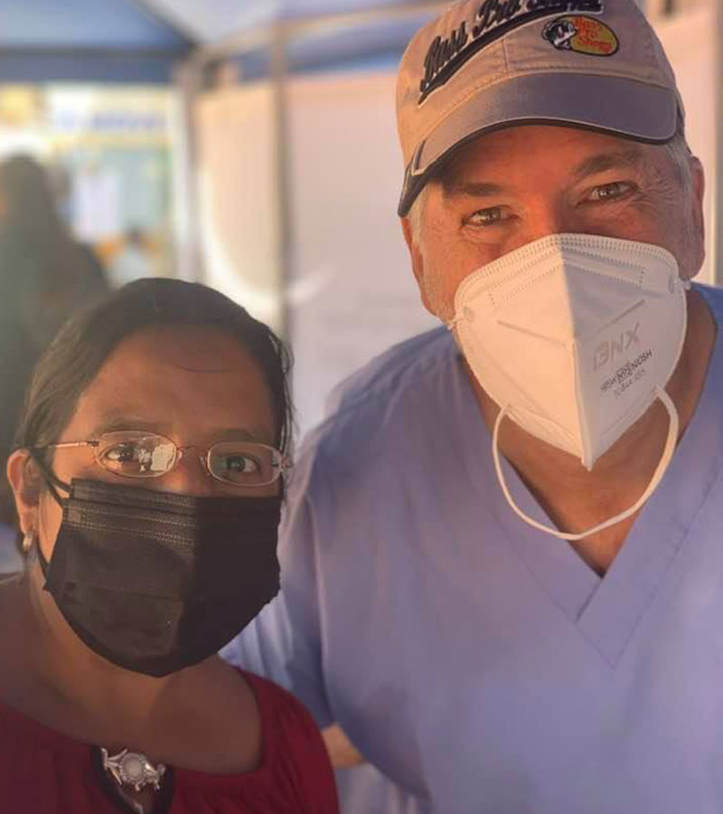Bryan Kaiser beside a woman in new eyeglasses in Peru, both wearing protective face masks.