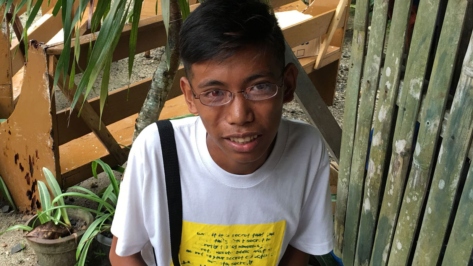 Young man in the Philippines wearing new eyeglasses provided by God’s Eyes vision clinic.
