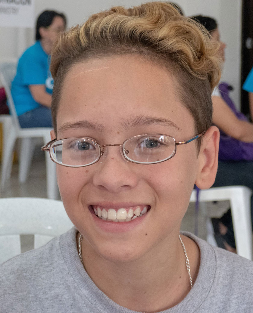 Smiling young boy in Colombia wearing new prescription eyeglasses provided by God’s Eyes vision clinic.
