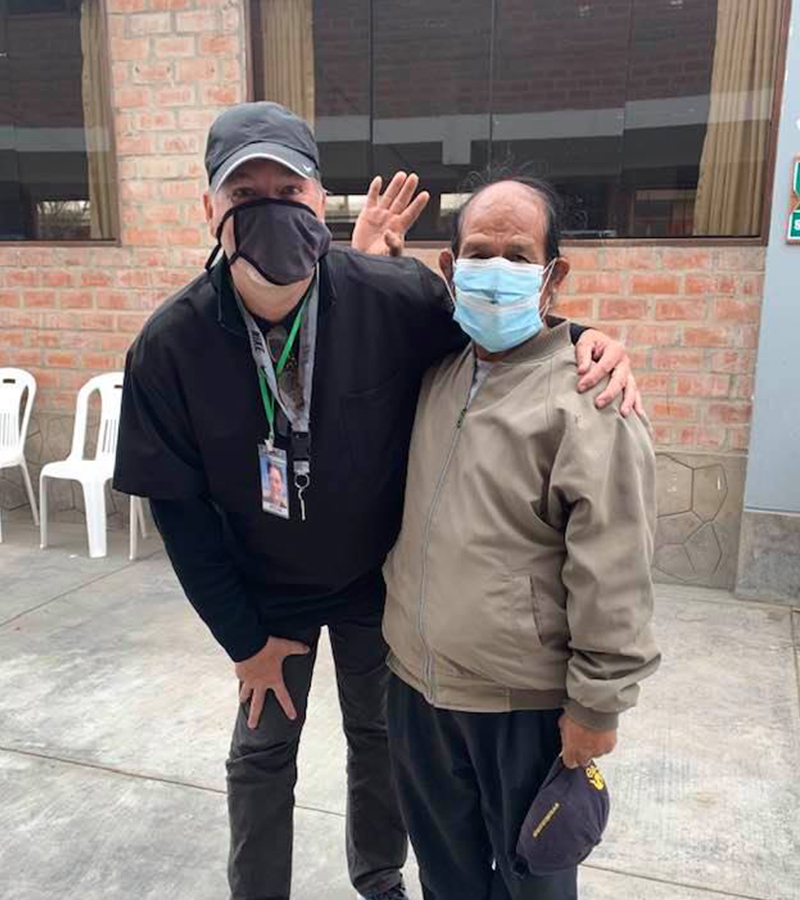 Bryan Kaiser and man in Peru wearing face masks, standing together during a vision clinic.